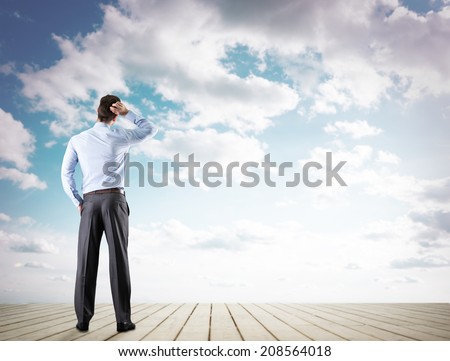 Back view of confident businessman looking at sky