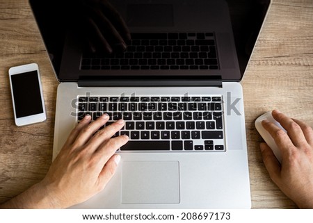 Male hands working on laptop, top view