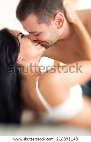 Positive sexy couple kissing in bed - shoot with lens baby