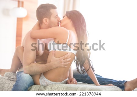 young passion lovers kissing on bed
