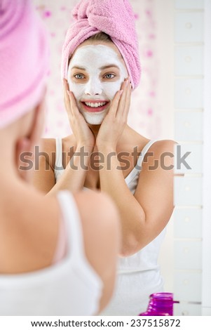 Young  woman applying facial cleansing mask, beauty treatments