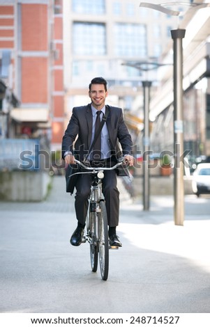 Carefree businessman riding a bicycle outdoors go to work
