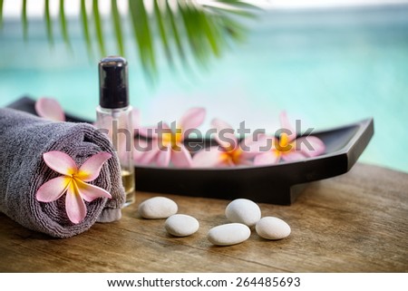 Balinese spa setting, pink frangipani with aromatherapy oil