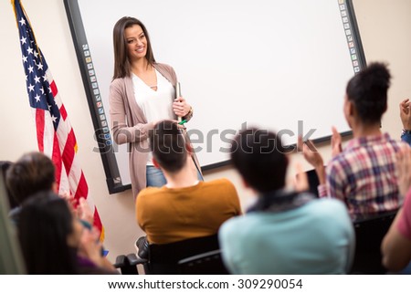 Good looking assistant finished lecture and students clapping hands