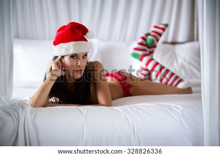 Female babe with Santa Claus hat in bedroom