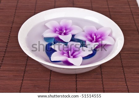 beautiful pink flower candles floating in bowl of water