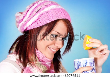 cute winter girl adding lemon to her tea