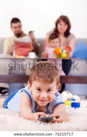 happy family with children sitting on sofa and  watching TV at home