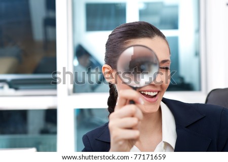 researching smiling business woman with magnifying glass to the eye