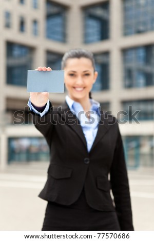businesswoman standing outdoor and showing business card