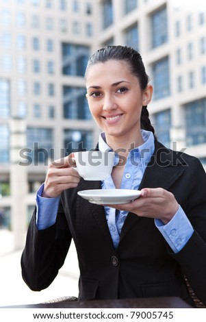 smiling business lady drinking coffee in business center