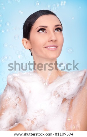 beautiful necked  woman  in foam and bubbles on blue background