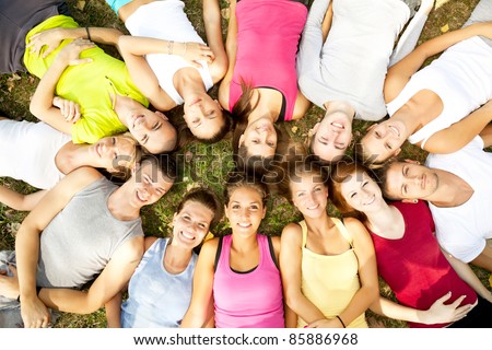 friends happy group in circle heads together on green grass,  outdoor