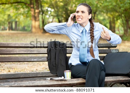 angry businesswoman  on mobile phone, facial expression with gestures ,  outdoor