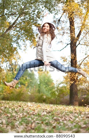 young girl jumping in autumn park, high jump