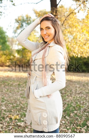 young fashion model posing in park in autumn collection