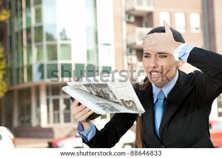 shocked woman reading newspaper on street, oh no bad news