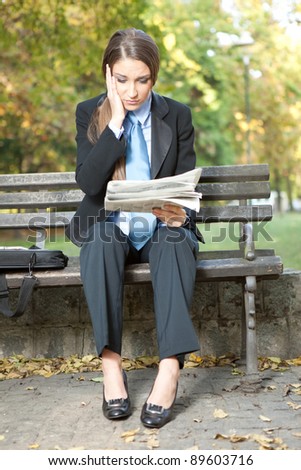 businesswoman reading newspaper with bad news, outdoor