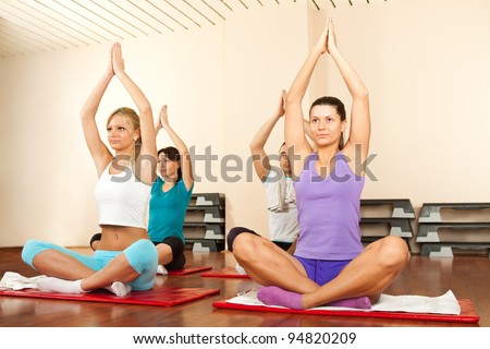 Group of people doing yoga on gymnastics mats