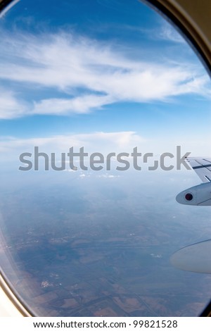 View of clouds and wing from airplane window