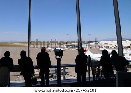Vancouver, BC Canada - September 13,  2014 : People inside YVR airport watching air canada airplane in Vancouver BC Canada.