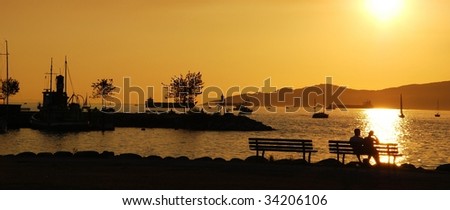 Silhouette of a couple enjoy beautiful sunset view in English Bay, Vancouver Canada