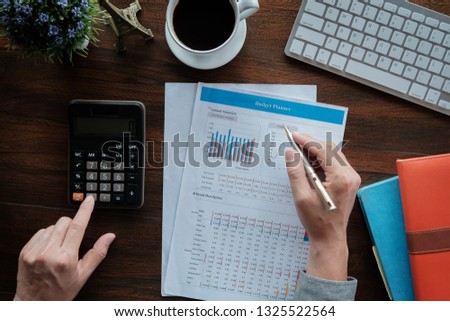 Business accounting concept, Business man using pen pointing  with data budget planner chart and calculator for calculate finanance plan  paper in office. Imagine de stoc © 