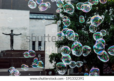 The rainbow bubbles from the bubble blower, statue on background