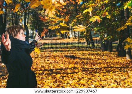 Young Woman Drop Up Leaves In Autumn Park