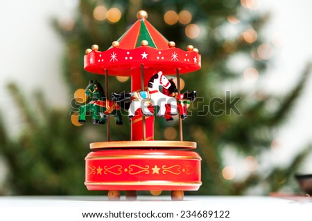 Red merry-go-round horse carillon, wooden carouse, christmas decoration, Christmas tree on background