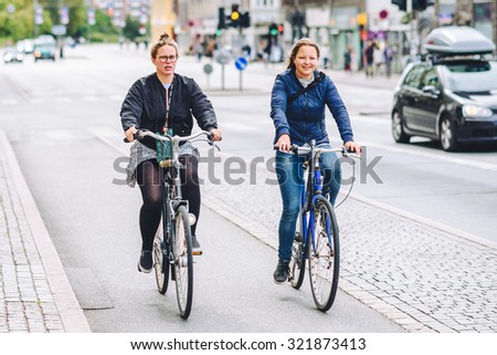 COPENHAGEN, DENMARK - AUGUST 01, 2015: People going by bike in the city. A lot of commuters, students and tourists prefer using bike instead of car or bus to move around the city.