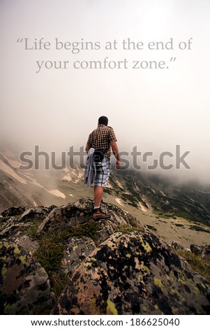 man on the edge on rock in fogy mountain, unknown inspirational quote above