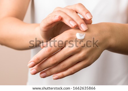 cold season hands skin protection. closeup woman applying protective cream on hands.
