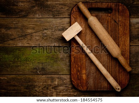 Rural vintage wood kitchen table with blank cook book and cooking tools.  Background with free recipe text space.