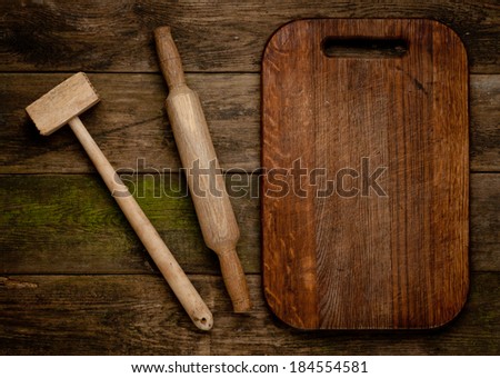 Rural vintage wood kitchen table with blank cook book and cooking tools.  Background with free recipe text space.