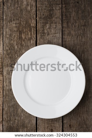 Empty plate on old wooden background. Top view.