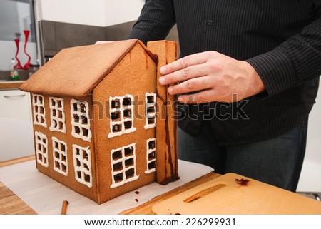Man putting together a gingerbread house