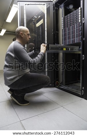System administrator working on a network server in a server room