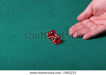 Dices being thrown in a craps game, or any kind of dice involved game, Dice are a clear red color on a green felt table