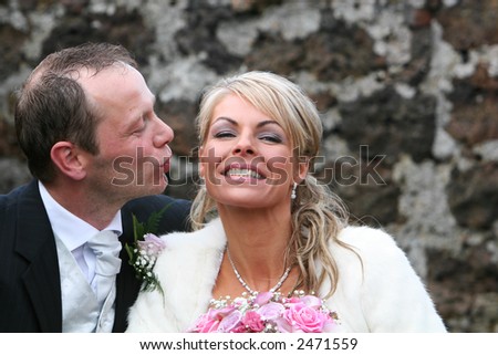 A very happy couple sitting together and smiling, very much in love, man about to kiss woman