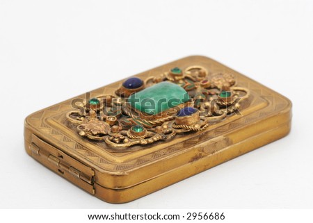 A close up of a gold jewel box with inlaid jewels, isolated on white