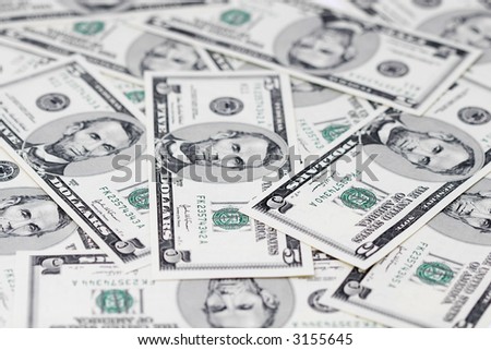 A close up of a bunch of 5 dollar bills shallow focus, focus on dollars letter