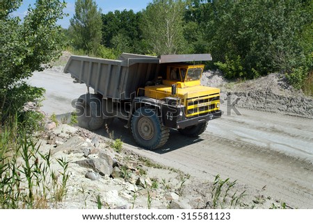 Kremenchug, Ukraine - 27 June 2008. Yellow dump truck driving on a road in a stone quarry