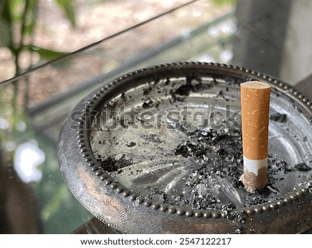 Similar – Image, Stock Photo Round glass ashtray with butts of cigarettes and colorful autumn leaves on a rustic wooden table with grain in autumn in the alleys of the old town of Detmold on the Teutoburg Forest in East Westphalia Lippe