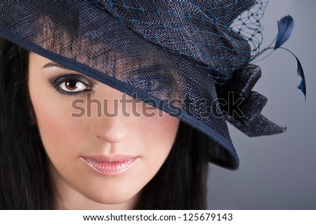 Portrait of young beautiful woman with professional evening style make up in vintage hat