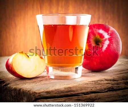Apple juice. Fresh organic ripe apples and glass of juice on old wooden table background. Image in vintage style