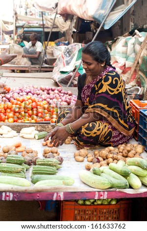 CHANNAI, INDIA - FEBRUARY 10: Indian woman selling greengrocery at market on February 10, 2013 in Chennai, India. Lot of different vegetables and herbs important ingredients of traditional Indian food