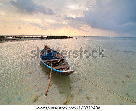 Sunset at tropical beach. Evening ocean landscape with Thai traditional boat  under dramatic stormy sky. Thailand, Koh Samui