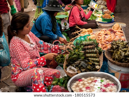 SIEM REAP, CAMBODIA - DEC 22, 2013: Unidentified Khmer woman selling traditional asian food rice in banana leaves on Dec 22, 2013, Siem Reap, Cambodia. Street food markets is popular tradition in asia