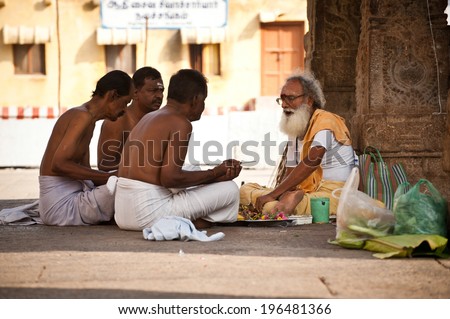 MADURAI, INDIA - FEBR 16: Hindu Brahmin with religious attributes providing ceremony and blessing pilgrim at holy place for hindu people Meenakshi Temple on Febr 16, 2013. India, Madurai, Tamil Nadu